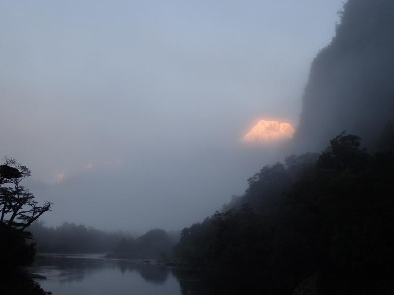 a snowy mountain peak appearing above the mist