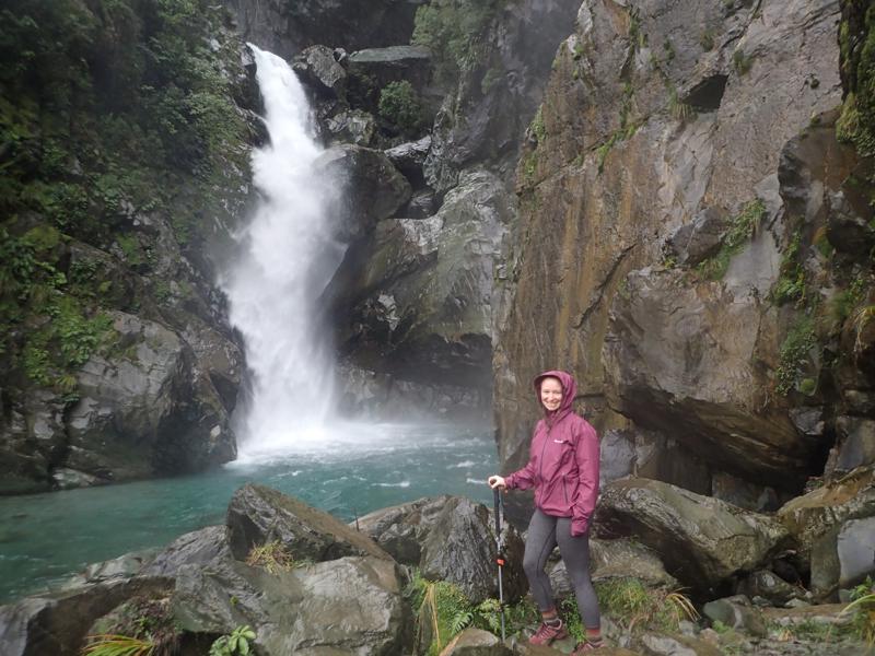 hiker infront of a dramatic rocky waterfall