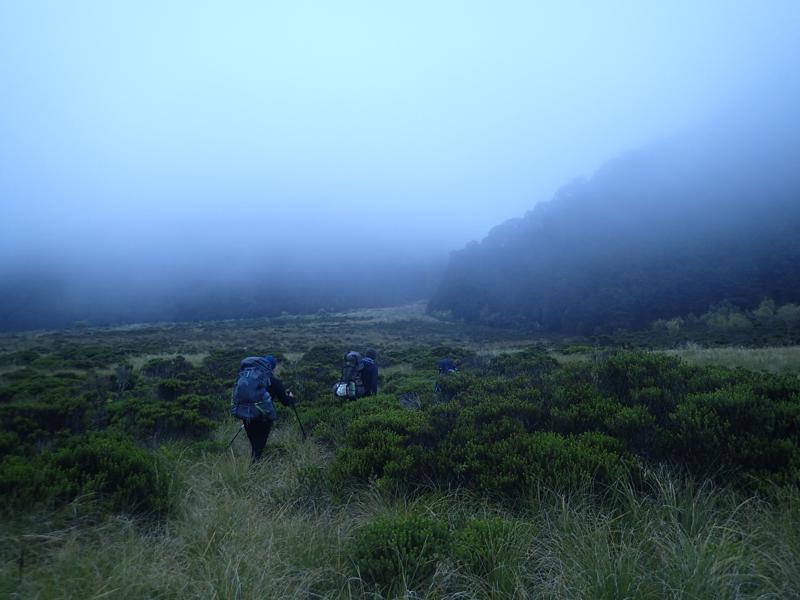 hikers on valley floor in cloud