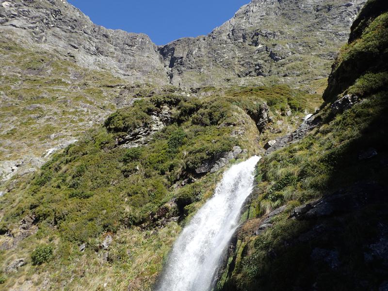 waterfall with mountains rising behind