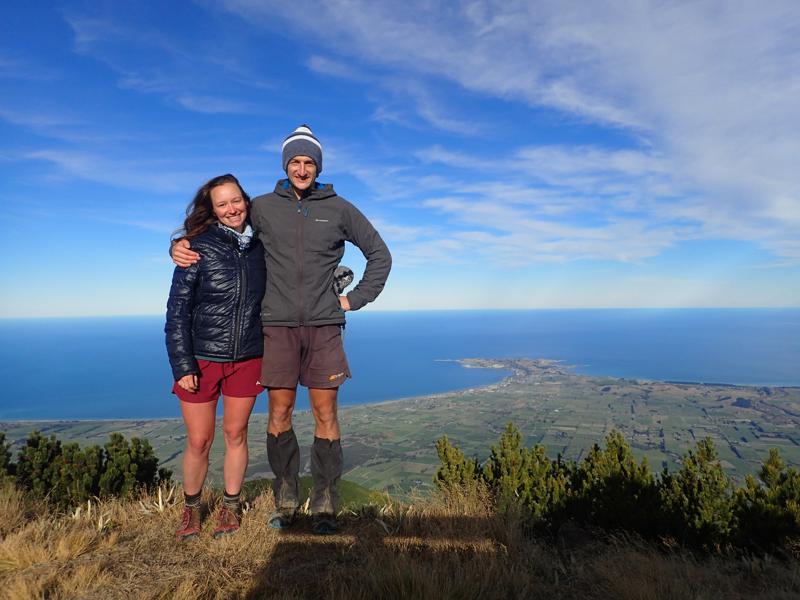 2 happy hikers with sea views and a peninsula behind