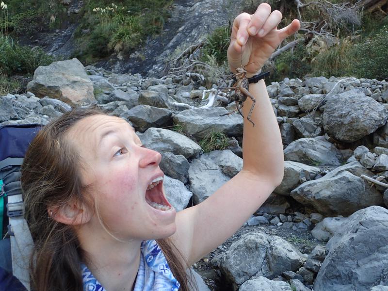 a girl holding a large dead insect up to her mouth