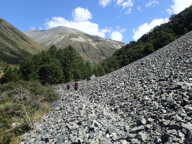 2 hikers walking along the base of a scree slope