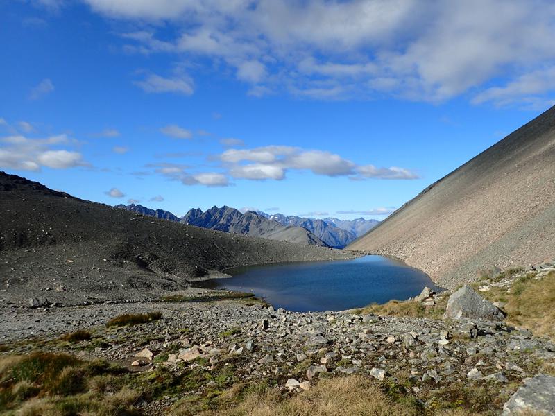 a small lake with scree slopes around