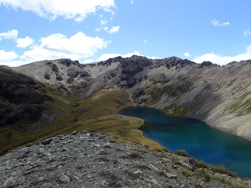 a blue lake with mountains beyond