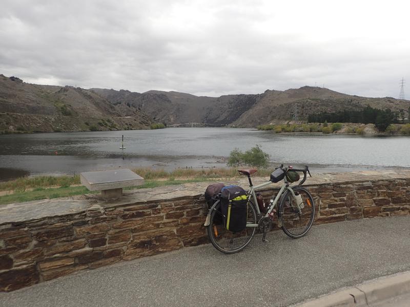 Bike against a wall with lake and hills beyond