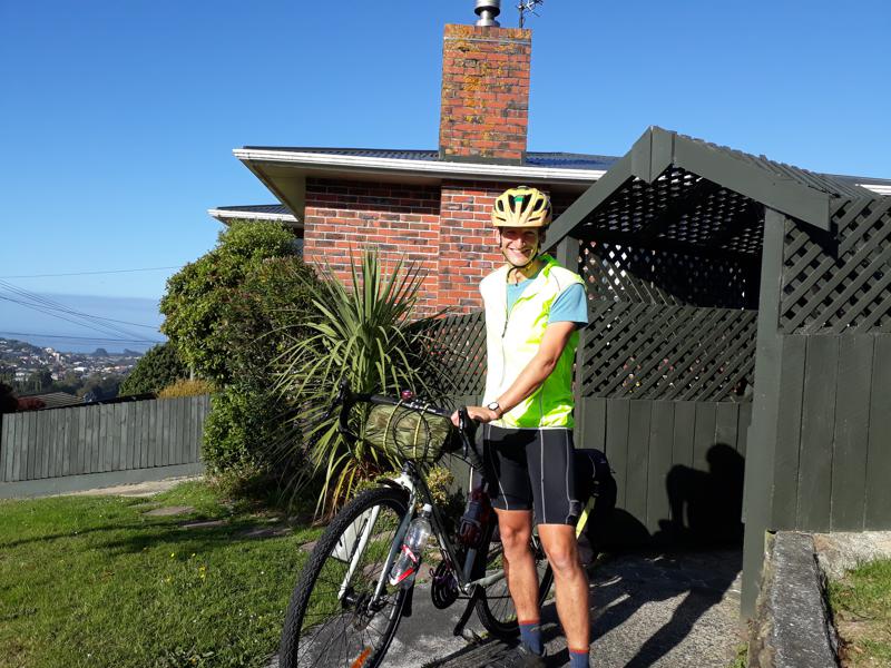 Cyclist standing beside his bike in sunshine