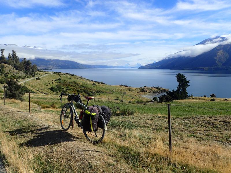Gravel road beside lake with blue skies