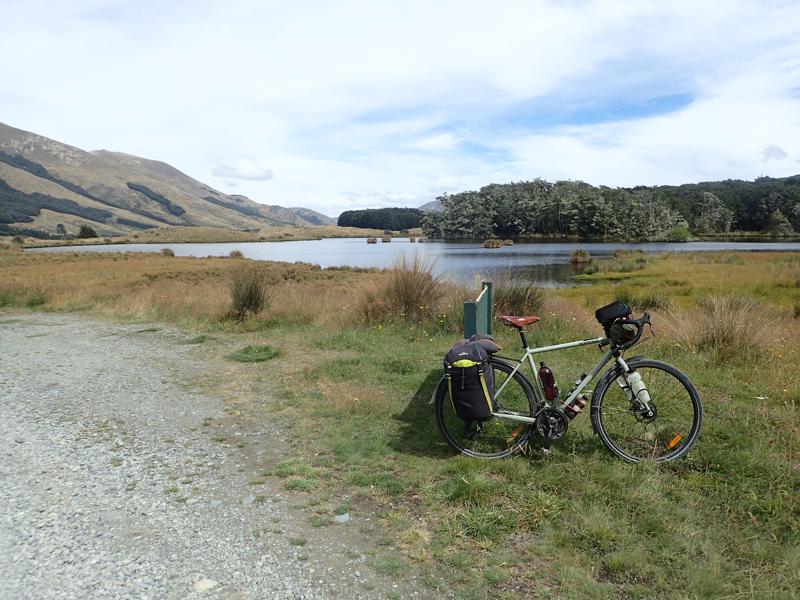 Bike resting with small lake and trees beyond