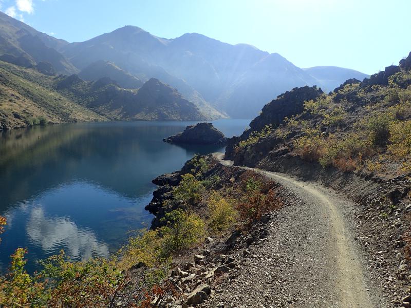 Narrow gravel track beside a blue lake