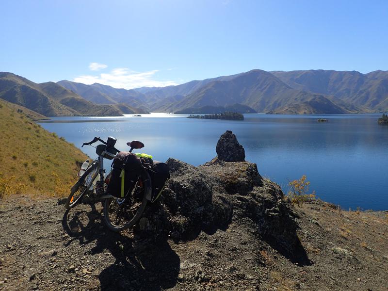 Bike resting in front of blue lake with blue sky