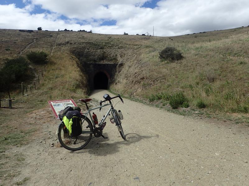 Bike in front of a small dark railway tunnel entrance