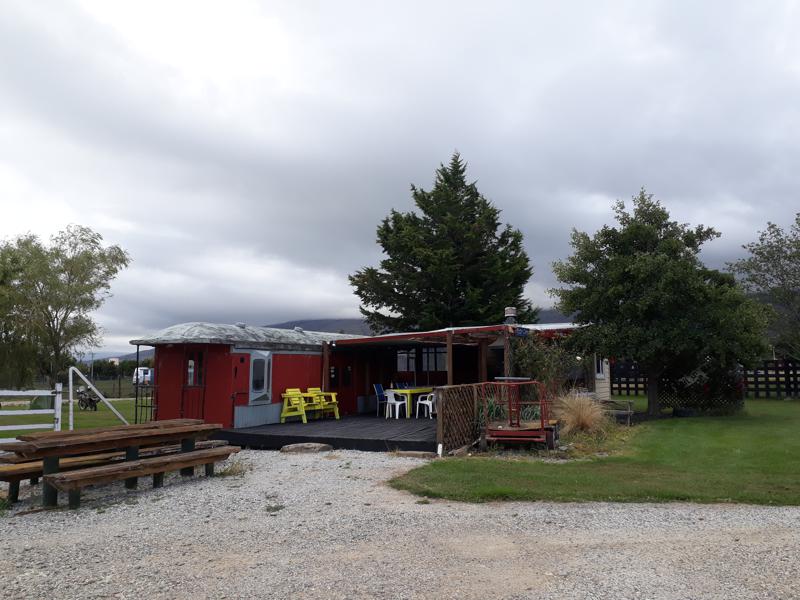 Campsite with a train carriage and seating outside